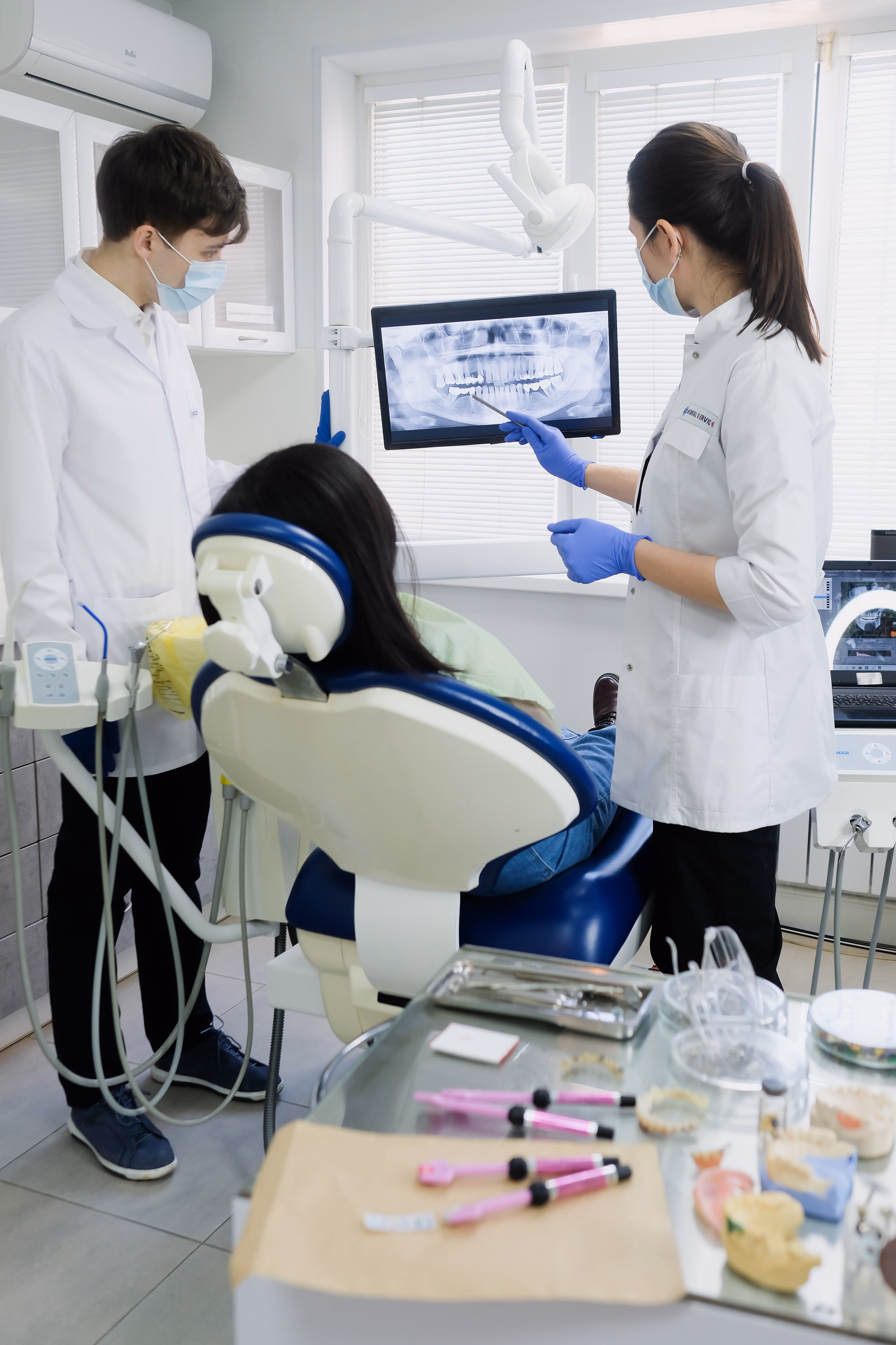 Dental team reviewing an X-ray on a screen with a patient in the dental chair